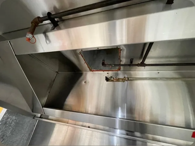 The same left hood interior after cleaning, with the stainless steel surfaces exposed.